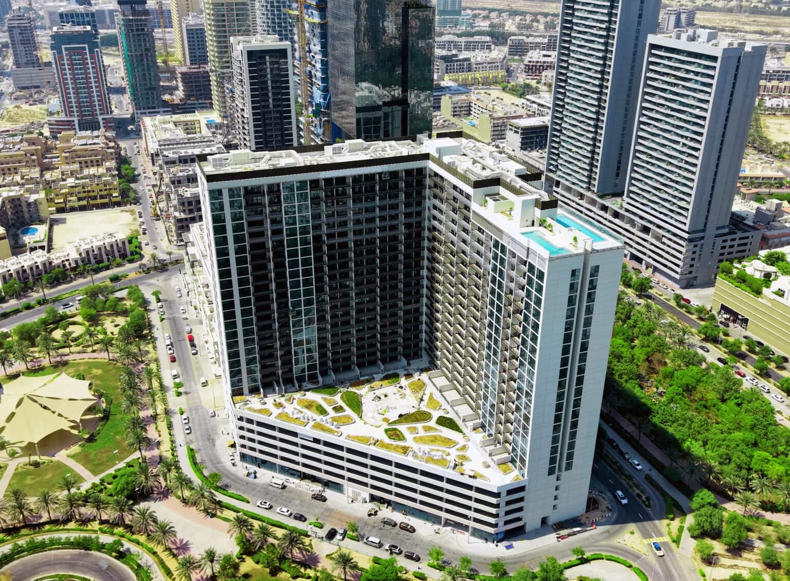 Luma Park Views in Jumeirah Village Circle after completion, aerial view of the towers, podium garden and rooftop pool